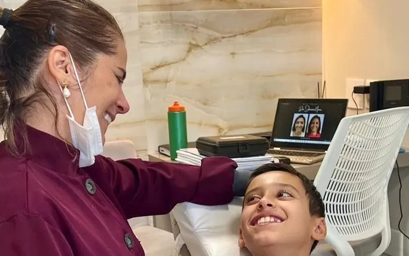 Dra. Janaína Nunes conversando com um paciente na cadeira