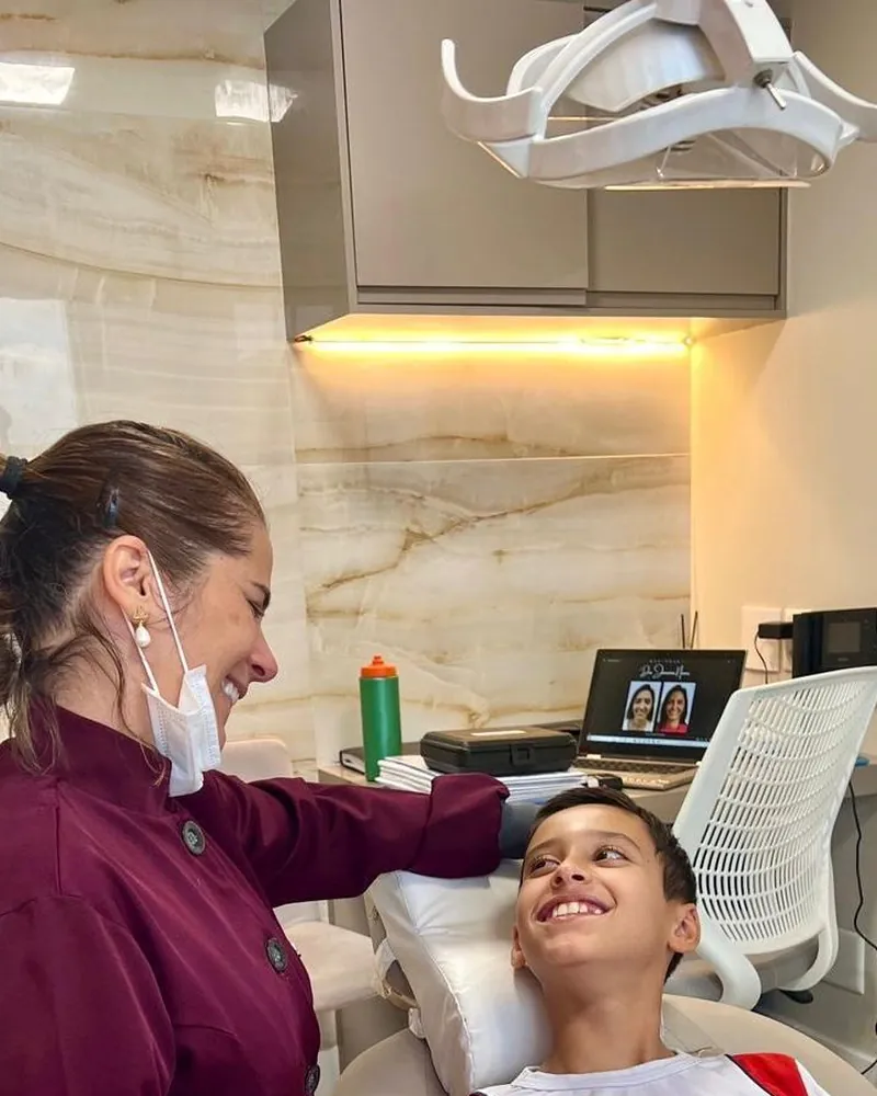 Dra. Janaína Nunes conversando com um paciente na cadeira